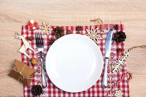 Festive table setting with cutlery, checkered napkin and Christmas decoration Stock Photos