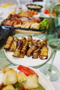 Festive table setting with eggplant rolls appetizer and wine glass Photos