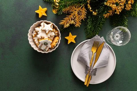 A festive table setting with an empty plate, napkin and cutlery and gingerbre Stock Photos