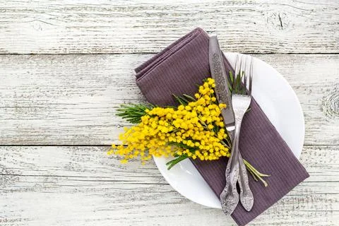 Festive table setting plate with napkin fork and knife and mimosa flower de.. Stock Photos
