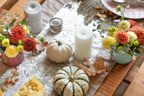 Festive table setting with pumpkins, candles and chrysanthemum flowers. Stock Photos