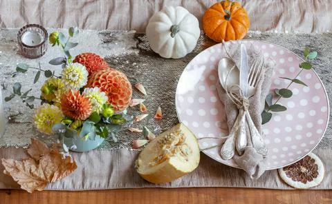 Festive table setting with pumpkins, candles and chrysanthemum flowers. Stock Photos