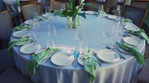 Festive table setting in restaurant. Crystal glasses, plates on banquet table Video stock 312768211