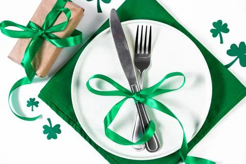 Festive table setting for St. Patrick's Day. Plate and cutlery on a green nap Stock Photos