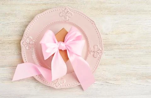 Festive table setting top view. Pink bow on plate on light background. Stock Photos