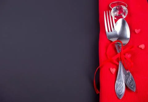 Festive table setting for Valentines Day with red napkin and cutlery. Copy sp Stock Photos