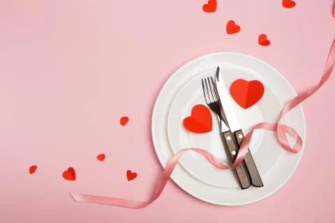 Festive table setting for Valentine's Day with fork, knife,  hearts on a red  Stock Photos