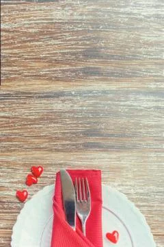 Festive table setting, white plate, silver cutlery  and red heart decoration  Stock Photos