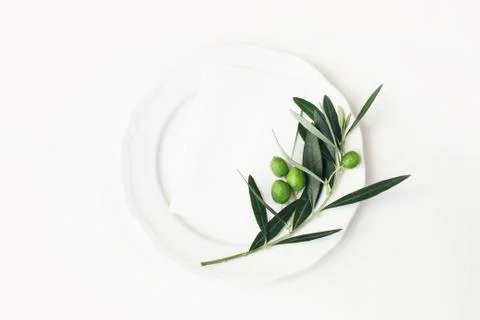 Festive table summer setting with olive leaves, branch and fruit on porcelain 写真素材