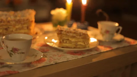 Festive table for tea and coffee with cake on the background of a candles fire. Video stock 101037703