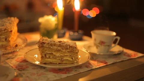 Festive table for tea and coffee with cake on the background of a candles fire. Video stock 101037730