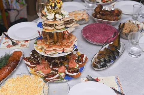Festive table with tiered stand full of appetizers and smoked fish. Stock-Fotos