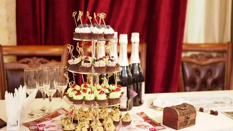 A festive table on which there are cakes, champagne bottles and glasses. Video stock 231094142