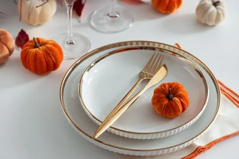 Festive Thanksgiving table setting with small pumpkins and elegant gold cut.. Stock Photos