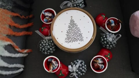 A festive tin with a Christmas tree design surrounded by decorative holiday elem Stock Footage 294704719