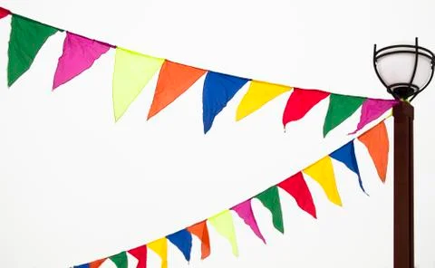 Festive triangular flags in the form of garlands hang tied to a lamppost. Dec Stock Photos