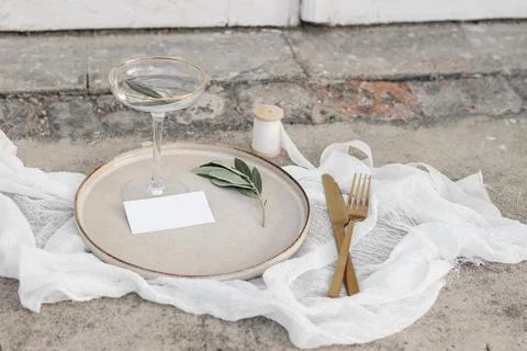 Festive wedding summer table setting. Golden cutlery, olive branch, glass of Stockfoto's