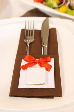 Festive wedding table setting with cutlery, napkin, ribbon bow and a chocolat Stockfoto's