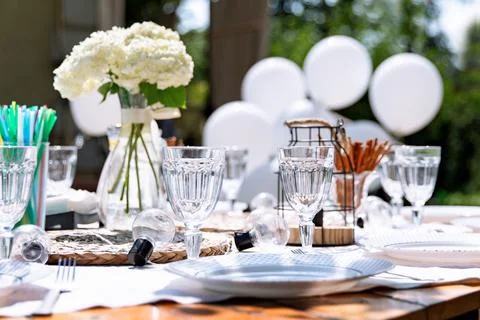 Festive white table setting in the backyard garden. Summer children's party Stock Photos