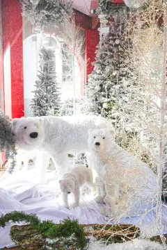 Festive window display featuring three polar bear figures and twinkling light Stock Photos