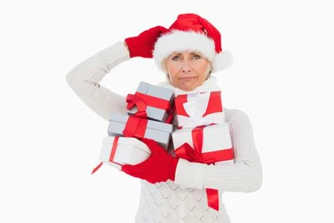 Festive woman scratching head and holding gifts Stock Photos