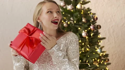 Festive woman shaking wrapped present gift box, christmas Stock Footage 166322927