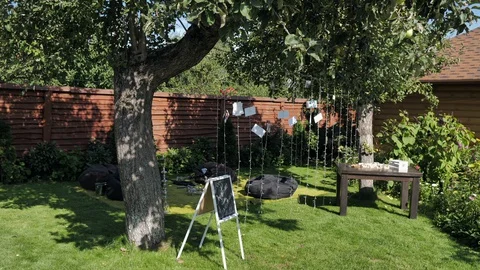 Festive zone in the yard. Relaxation area with hookahs and puff chairs. 库存影片 128597982