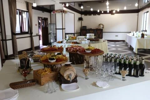 Festively arranged buffet table with appetizers, beverages, and glasses insid Stock Photos