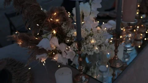 A festively decorated table with flowers, luminous garlands Stock Footage 161886164