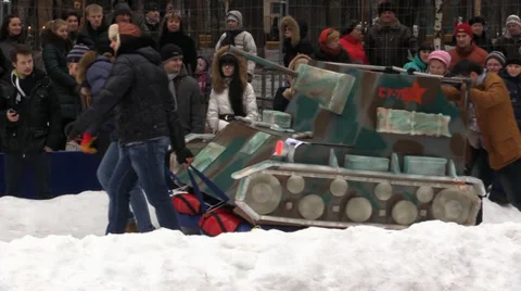 Festivities. Young people pulling disguised tank on competition. Russia. Stock Footage 35456624