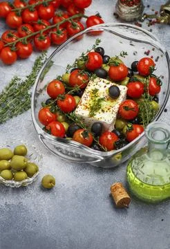 Feta cheese is ready for baking with cherry tomatoes, black and green olives, Stock Photos