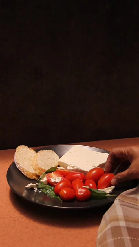 Feta cheese tomato bread platter vertical hand picking food Video stock 321760226
