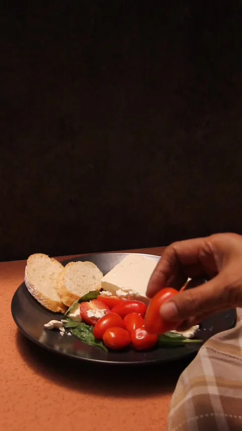 Feta cheese tomato bread platter vertical hand putting food Stock Footage 321760227
