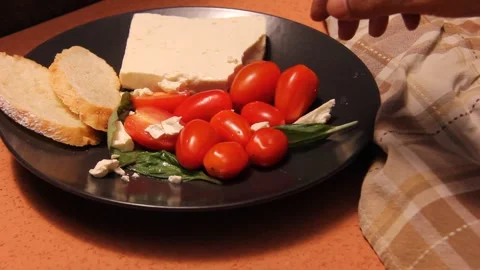 Feta cheese tomato bread platter horizontal hand putting food Stock Footage 321760388