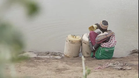 Fetching water from a dirty pond. Stock Footage 319308729