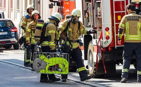  Feuerwehrmänner tragen bei einem Tanklöschfahrzeug Atemschutz und holen W. Stock Photos