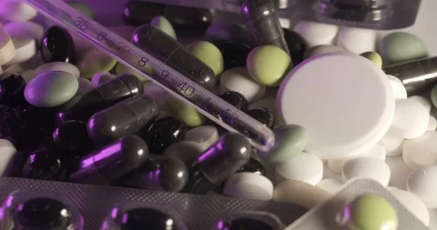 Fever thermometer on pills and supplement capsules. Stock Footage 125963629