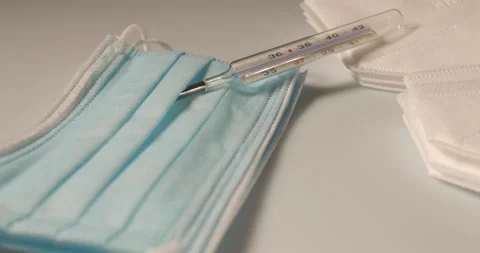 Fever Thermometer on surgical face mask. Diagnostic tool and protection Stock Footage 176126789