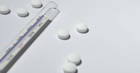 Fever Thermometer with white pills on white surface. Medicine, clinical thermo Stock-Footage 146580382