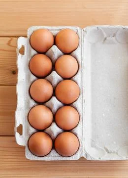 A few brown eggs among the empty cells of a large cardboard bag Stock Photos