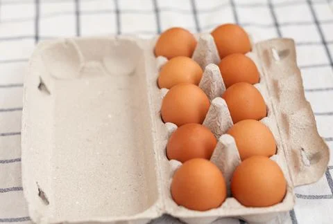 A few brown eggs among the empty cells of a large cardboard bag Stock Photos