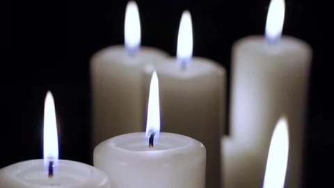 A few candles are burning on a black background. Stock Footage 102944045