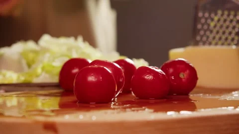 A few cherry tomatoes have been washed and laid out on a wooden board for Stock Footage 300810808