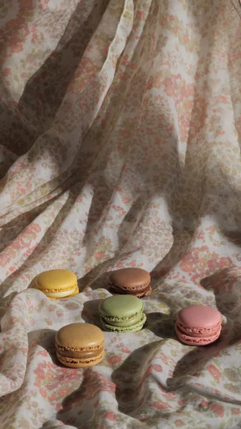 A few macaroons on a white tablecloth, with a shadow, vertical video Stock Footage 233255854