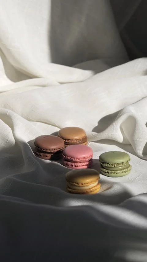 A few macaroons on a white tablecloth, with a shadow Stock Footage 233255855