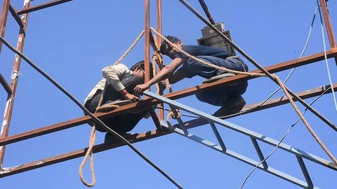 Few men welding iron frames on the city billboards Stock Footage 100315098