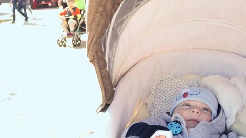 Few months old baby in carriage zoom video with street background Stock Footage