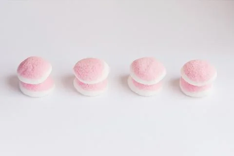 A few pieces of pink and white candy and jelly is on a white background Stock Photos