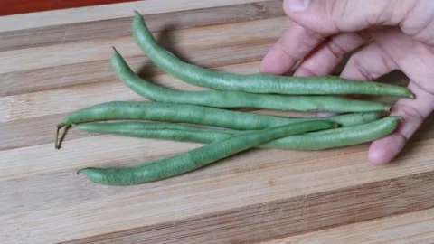 Few Pieces of Raw Beans Vegetables in a Chopping Board Stock Footage 236774339