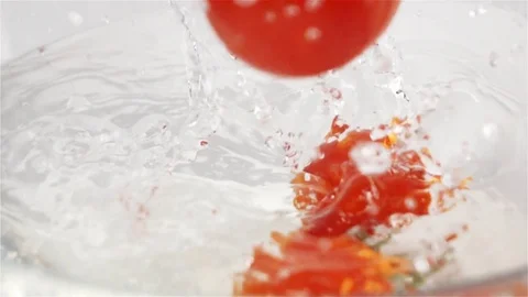 Few red tomatoes falling down into water with splash Stock Footage 76811853